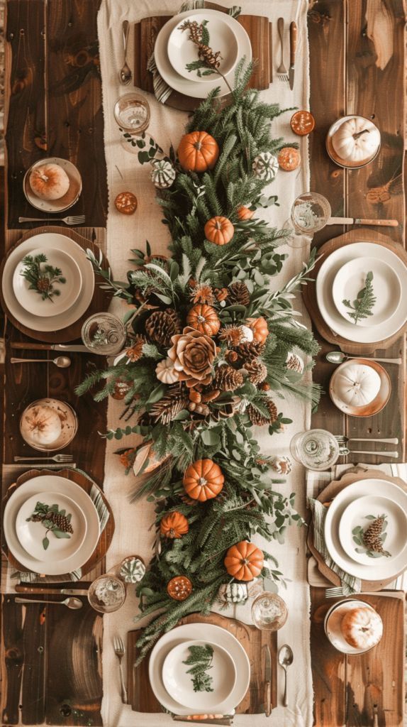 Overhead view of a fall table runner with mini pumpkins, pinecones, and eucalyptus